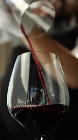 Red wine in a transparent decanter. Slow motion video, close-up. The bartender prepares wine for consumption.