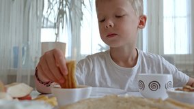 Blond boy dipping golden honey onto crispy waffle, enjoying breakfast with colorful fruits and fluffy pancakes surrounding cheerful meal scene - Powered by Shutterstock - Get 15% off with code: PIKWIZARD15