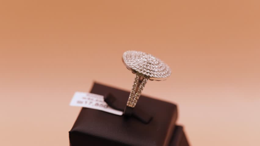 Diamond Halo Ring: A Circle of Brilliance
This captivating video focuses on a stunning circular diamond ring. The ring features a large brilliant-cut diamond surrounded by sparkling smaller ones.