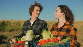 Two young farmers with crates of fresh vegetables smile proudly on farmland, highlighting eco-friendly agriculture, rural lifestyle, and the value of family farming. - Powered by Shutterstock - Get 15% off with code: PIKWIZARD15