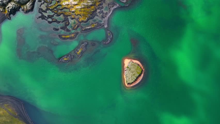Aerial drone view of nature in Landmannalaugar in Iceland with colorful rhyolite lava field, and a cyan lake.