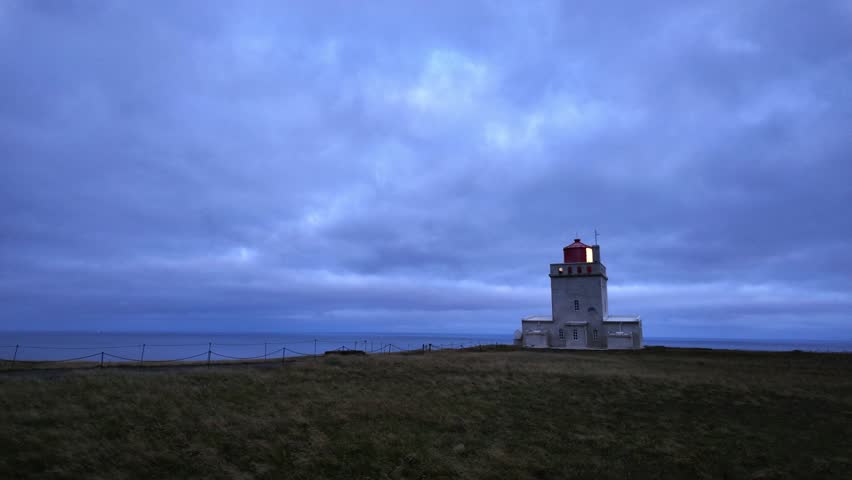 An iconic lighthouse dominates the coastline, its powerful light sweeping across seemingly infinite ocean expanses, serving as both practical navigational aid and poetic symbol of safe passage.