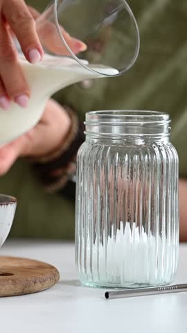 Woman Pours Milk Into A Jar For Iced Matcha Latte Making