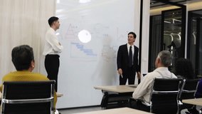 Business meeting and presentation in modern office. Team listen speaker explaining ideas on whiteboard with charts and diagrams. Concept of teamwork leadership corporate training and communication. - Powered by Shutterstock - Get 15% off with code: PIKWIZARD15