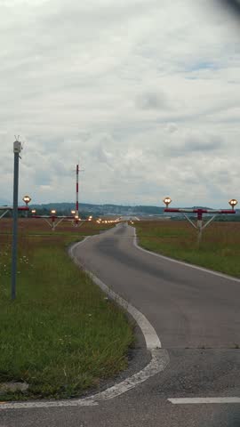 Big passenger airplane landing in Zurich airport at the evening. Plane flying down, on landing strip, rear view. Vertical video
