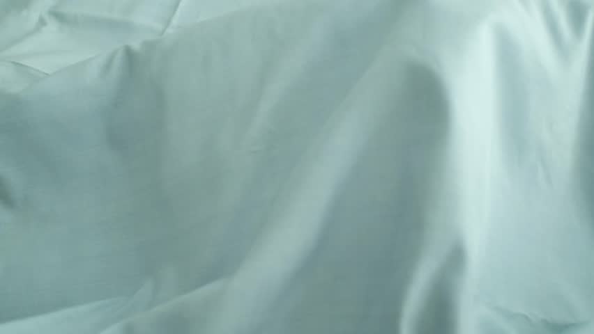 Closeup video of hands touching soft blue silk fabric. Appreciating pleasant texture of high quality textile for clothes. Soft and cozy textile. Premium quality silk fabric for luxury clothes.