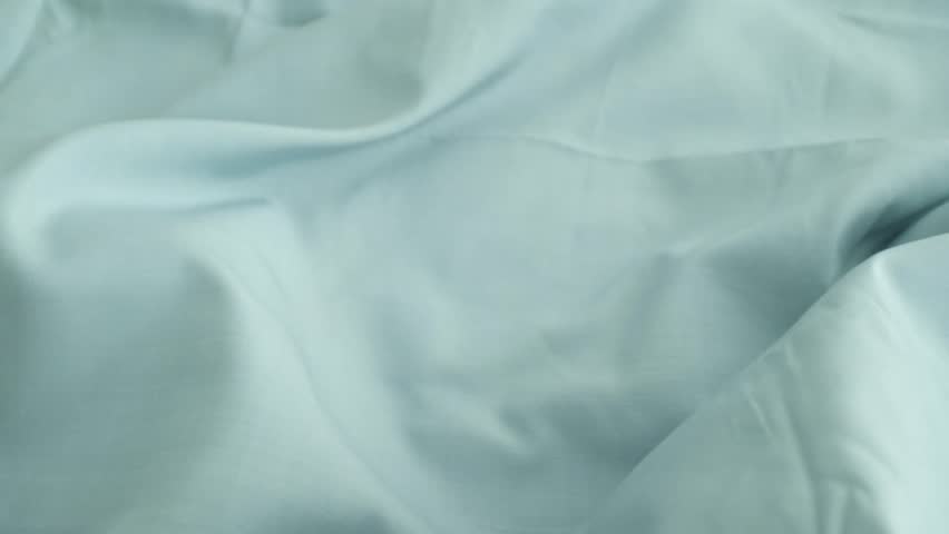 Closeup video of hands touching soft blue silk fabric. Appreciating pleasant texture of high quality textile for clothes. Soft and cozy textile. Premium quality silk fabric for luxury clothes.