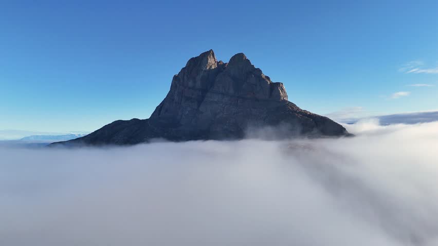 Town Uummannaq during summer in northern West Greenland beyond the Arctic Circle. Greenland, Danish territory. Large mountains and glaciers in the background. Misty morning. Fjord in Greenland. Aerial
