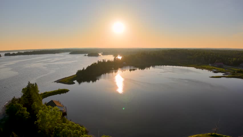 Aerial drone footage of a golden sunset over tranquil lake waters and forested islands in Michigan’s Upper Peninsula.