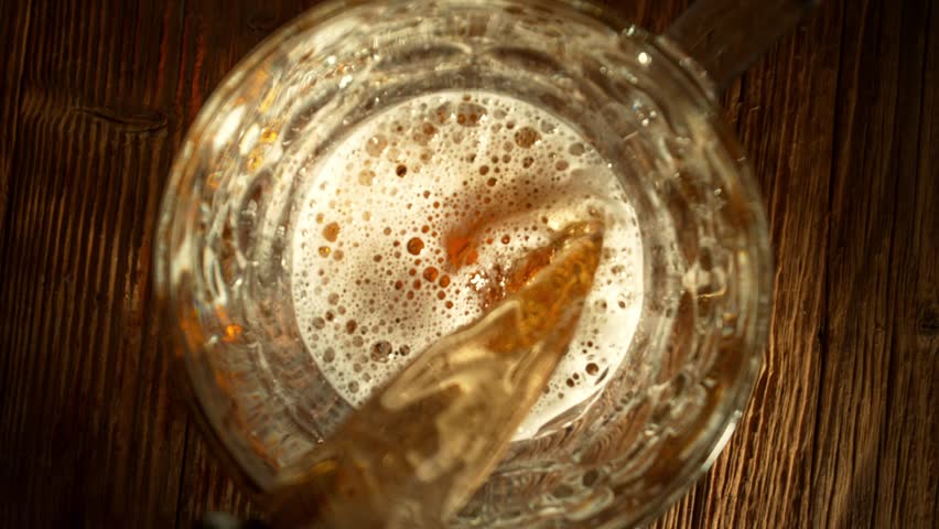 Super Slow Motion of Pouring Beer into Pint Glass, Top Down View, Camera Move. Filmed on High Speed Cinema Camera, 1000 fps.