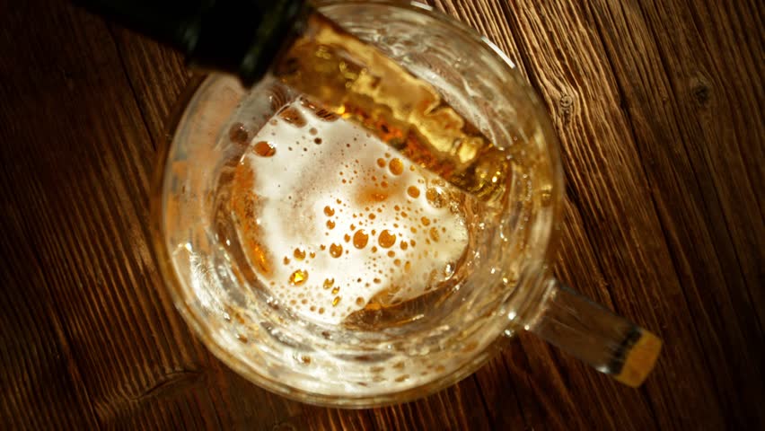 Super Slow Motion of Pouring Beer into Pint Glass, Top Down View, Rotating Camera Move. Filmed on High Speed Cinema Camera, 1000 fps.