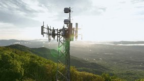 Cell tower on a mountain peak overlooking vast American landscape at sunrise. Green forests, rolling hills and bright sky highlight the mix of technology and nature in rural America. - Powered by Shutterstock - Get 15% off with code: PIKWIZARD15