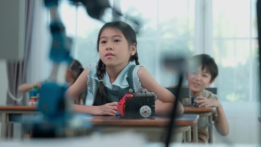Young Engineers: multi ethnic Children engrossed in building and testing small robotics, showcasing curiosity, teamwork, and early STEM education. The focus robot and children hands-on engagement.