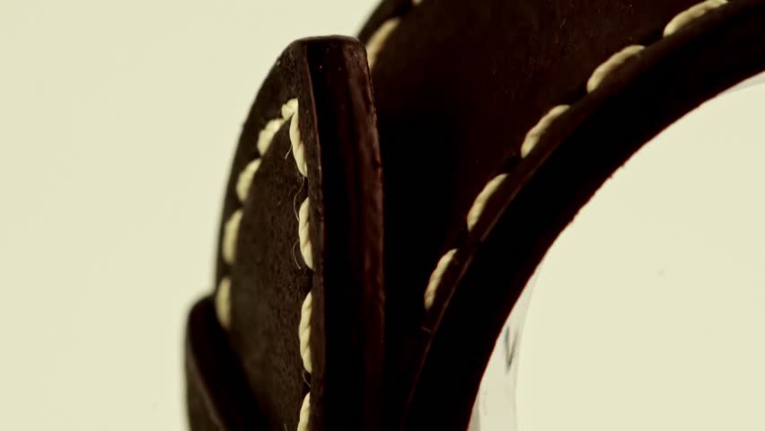 Tilt down on leather watch strap showing buckle detail, elegant product footage