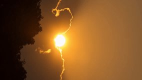 Vertical video - Timelapse of the sun setting behind the silhouette of the clouds - Powered by Shutterstock - Get 15% off with code: PIKWIZARD15