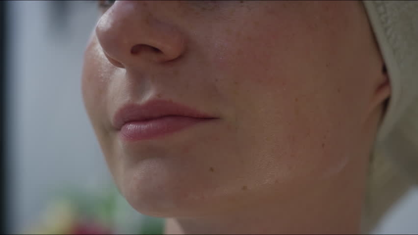 Young woman with sensitive face skin applying cream to soothe her skin, reduce redness and irritation, close up shot. Cosmetics concepts.