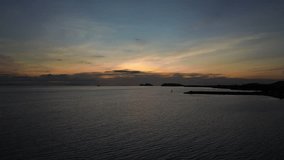 Aerial drone footage of Baan Tai Pier on Koh Phangan island in Thailand during a golden sunset, with calm ocean waters and distant islands visible in the background. - Powered by Shutterstock - Get 15% off with code: PIKWIZARD15