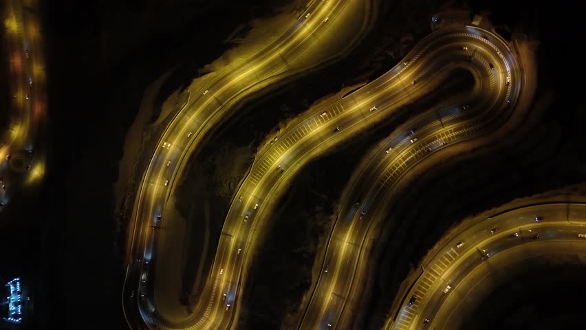 Top down night traffic highway at city lights aerial. Illuminate cityscape. Urban road with modern buildings. Downtown district at twilight. Architecture landmark.oman