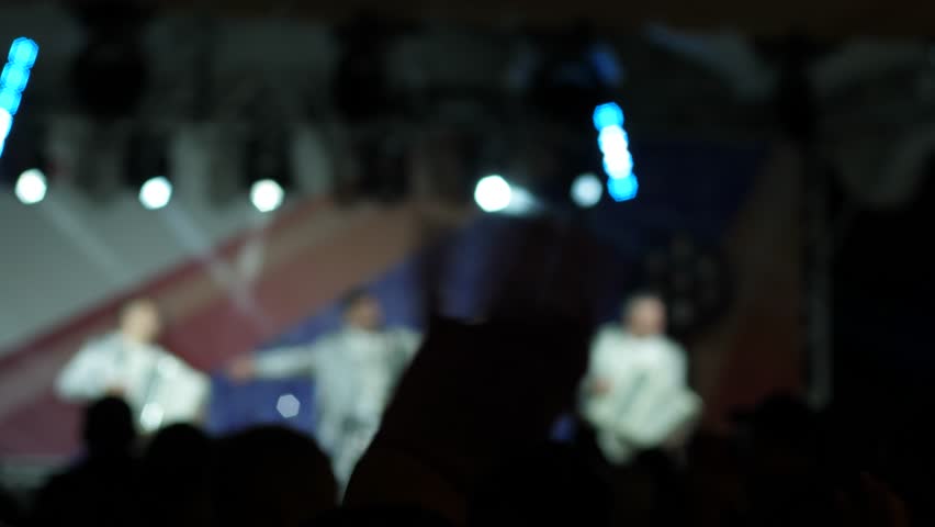 ensemble of artists with accordions perform on stage at a concert in front of a crowd of spectators in out of focus, concert of accordionists on stage, applause from the audience