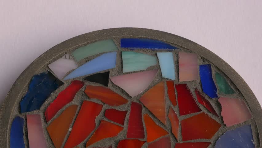 Colorful mosaic art piece evolves from abstract shapes to a heart design, highlighting vibrant glass fragments and detailed craftsmanship throughout the scene 