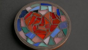 Colorful mosaic heart design on a circular base, revealing intricate patterns and vibrant hues, capturing the artistic flow and craftsmanship in motion  - Powered by Shutterstock - Get 15% off with code: PIKWIZARD15