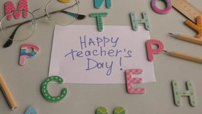A vibrant scene featuring colorful letters and a handwritten note expressing Happy Teacher's Day with glasses and pencils nearby. Happy teacher's day concept  - Powered by Shutterstock - Get 15% off with code: PIKWIZARD15