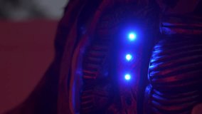 Extreme close-up of a Halloween cyborg with a bright red glowing eye and metal wires. Night outdoor yard decoration creates a spooky sci-fi horror mood. - Powered by Shutterstock - Get 15% off with code: PIKWIZARD15