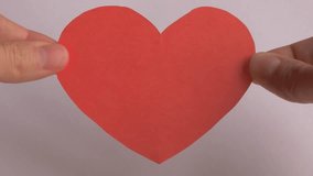 Hands are holding a red paper heart, illustrating a smooth transition in shape, representing love and care for World Heart Day awareness. World heart day concept  - Powered by Shutterstock - Get 15% off with code: PIKWIZARD15