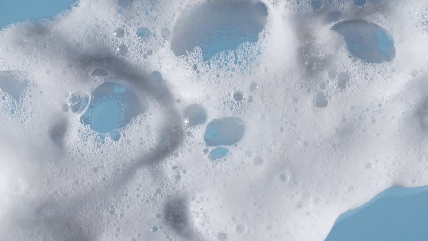 Texture of white soap foam with bubbles abstract background. Soap sud macro structure. Bathtup Soap Foam. Natural White Shampoo Bubbles Motion.
