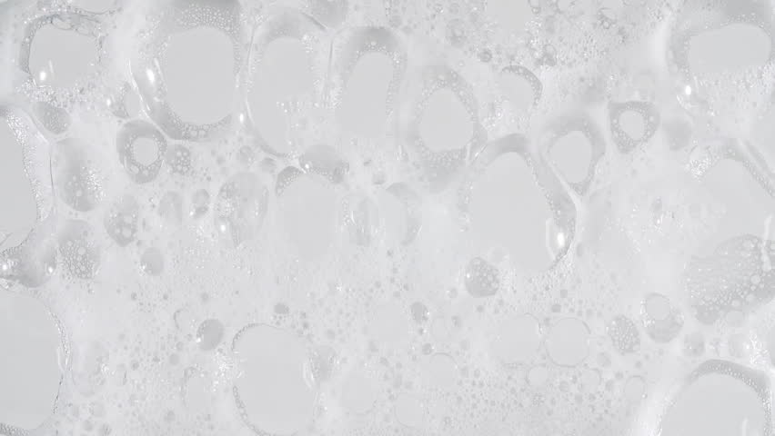 Texture of white soap foam with bubbles abstract background. Soap sud macro structure. Bathtup Soap Foam. Natural White Shampoo Bubbles Motion.