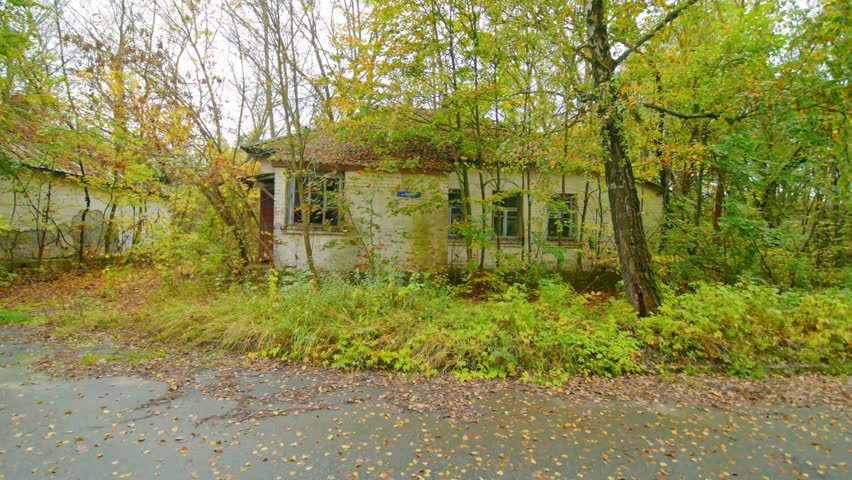 Footage of the dilapidated Conscription Point building located on Lenin Street within the Chernobyl Exclusion Zone. The scene captures the haunting atmosphere of an abandoned structure reclaimed by na