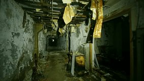 Footage captures the haunting and desolate atmosphere of an abandoned corridor within the Chernobyl Exclusion Zone. The scene features crumbling walls, a dilapidated ceiling, and debris scattered acro - Powered by Shutterstock - Get 15% off with code: PIKWIZARD15