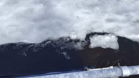 Blue jacket man and a black clothed man with a cap on a wooden pier pulling in synchrony a rope ferry that is stuck behind and ice sheet in frozen lake. Neverthless their effort the ferry is stuck. - Powered by Shutterstock - Get 15% off with code: PIKWIZARD15