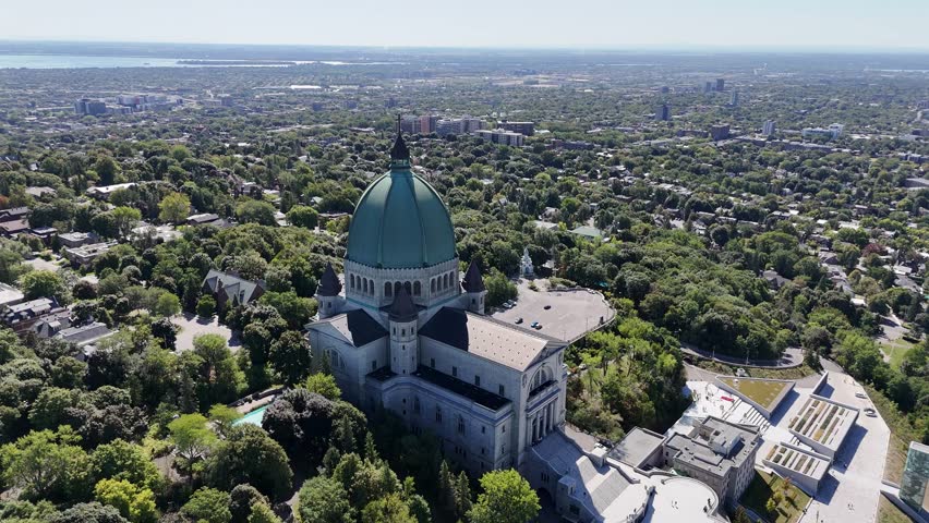 Extended 360° drone circle of Saint Joseph’s Oratory, featuring its dome, iconic stairs, fountains, green surroundings, Montreal skyline, and the St. Lawrence River in the distance