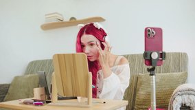 Young woman with pink hair and playful cat ears using a smartphone while sitting at a desk in a cozy room during the day - Powered by Shutterstock - Get 15% off with code: PIKWIZARD15