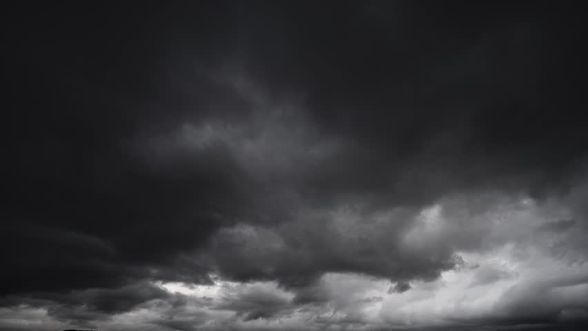 A timelapse shot of dark storm clouds gathering in the sky, creating a dramatic and moody scene