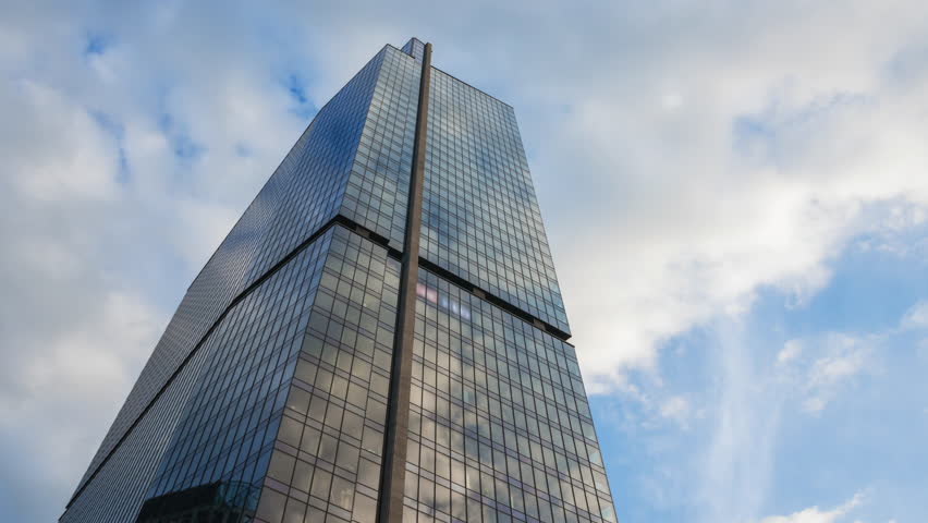 Low angle hyperlapse motion time-lapse downtown high-rise glass skyscrapers on sunny day, financial district looking up tall modern architecture office buildings city street, blue sky white clouds
