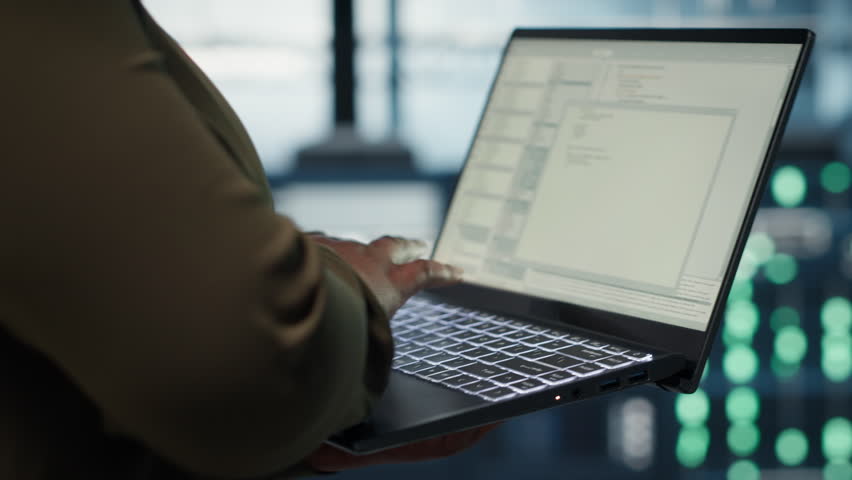 Close up of software developer working in data center to optimize network infrastructure. Programmer in server farm diagnosing and resolving equipment malfunctions using device
