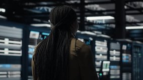 Data center manager conducts security audits to protect against cyber threats and errors. Employee walking between server room rows, ensuring compliance with industry standards, camera B - Powered by Shutterstock - Get 15% off with code: PIKWIZARD15