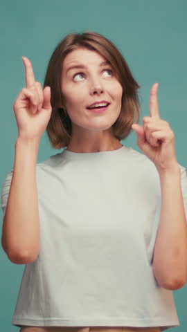 Portrait of joyful hispanic woman demonstrating copy space ad advert isolated over blue color background.