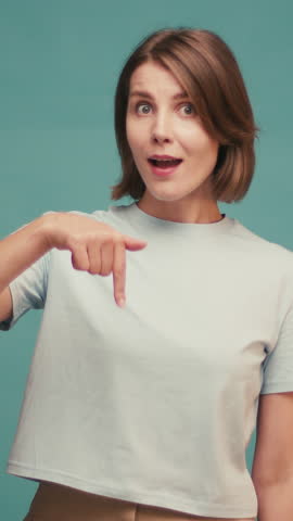 Portrait of joyful hispanic woman demonstrating copy space ad advert isolated over blue color background.