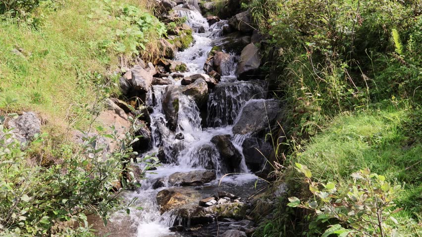 Before the grand Staubifall waterfall, smaller cascades tumble gently over mossy rocks, adding soothing sound and beauty to the alpine trail through Uri’s wilderness. Switzerland, August 14, 2025