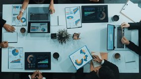 Top down aerial view of business people discussing about financial strategy on table with document and tablet display investment statistic at meeting. Diverse team brainstorm about plan. Directorate. - Powered by Shutterstock - Get 15% off with code: PIKWIZARD15
