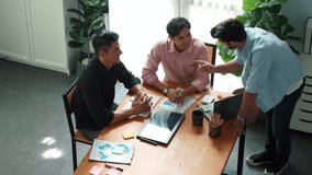 Top view of skilled project manager talking about financial graph to investors while sitting at meeting table with data analysis document. Diverse team discussing and brainstorming idea. Convocation. - Powered by Shutterstock - Get 15% off with code: PIKWIZARD15