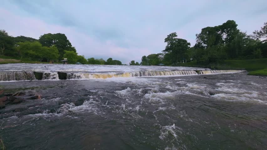 Scenic River Waterfall with Flowing Rapids in Nature
Beautiful view of a river waterfall with strong flowing rapids and surrounding greenery. Natural landscape scenery perfect for travel, tourism, rel