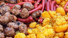 Meatballs and sausages with potatoes frying in a large pan. Slow motion - Powered by Shutterstock - Get 15% off with code: PIKWIZARD15
