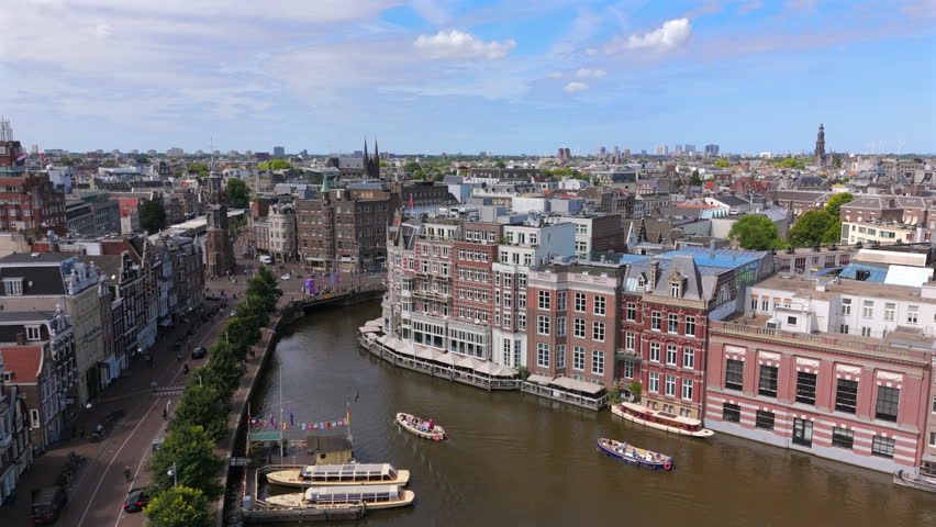 Experience stunning aerial footage of Amsterdam, perfectly showcasing its iconic canals, historic architecture, and vibrant city life that captures the essence of this beautiful European destination
