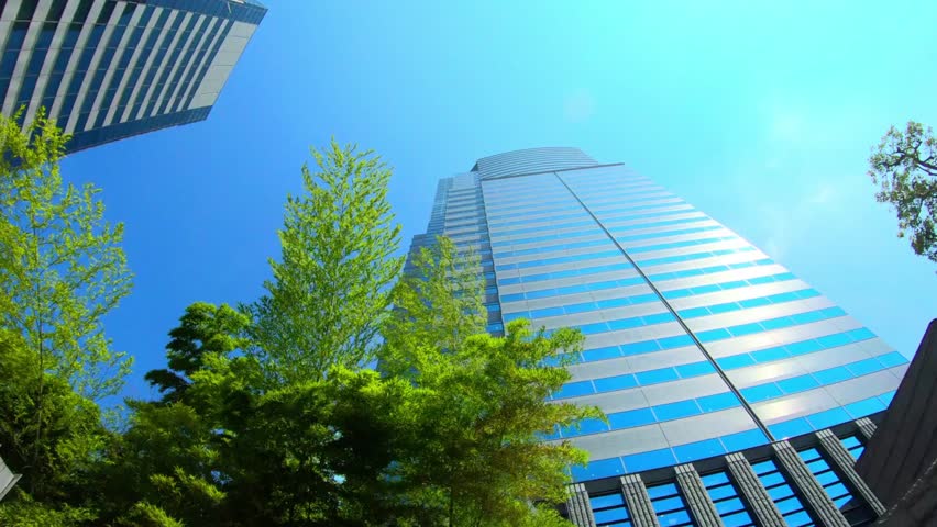 Looking up at modern skyscrapers against a clear blue sky in a vibrant city