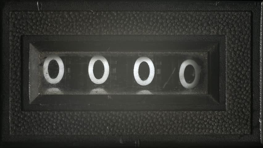 Close-up of an old mechanical frame counter dial scrolling through numbers. Useful for concepts of time, years passing, countdowns, retro technology, or measurement.