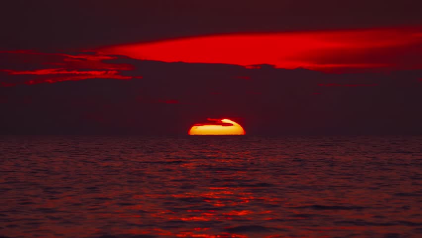 Late Golden sunset over Croatian Adriatic Sea. Waves and red clouds and water shimmer. Cinemagraph